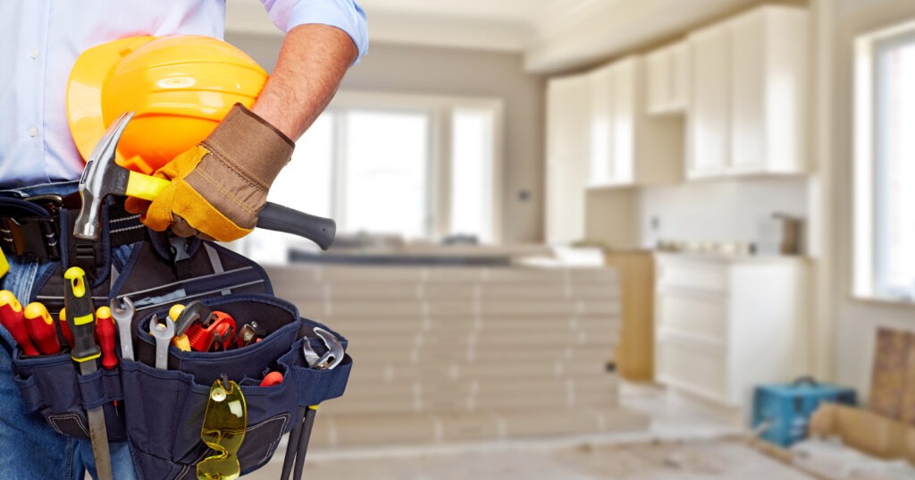 A construction worker holding a tool belt in his hands